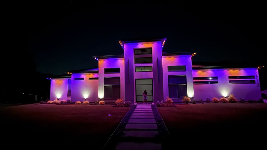 Modern home with purple and warm architectural uplighting